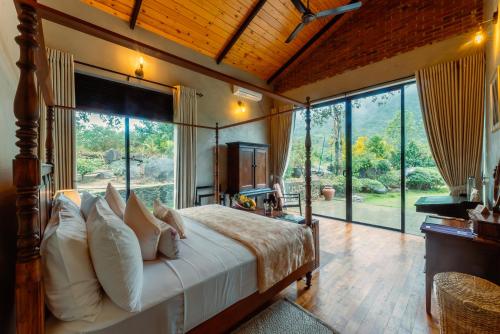 a bedroom with a large bed with a large window at Rosewood Manor in Botiyatenna