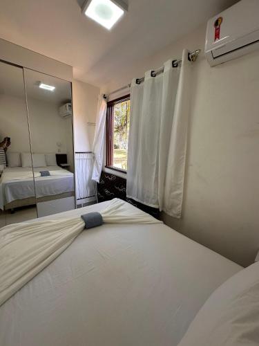 a bedroom with two beds and a mirror at Jubiabá - 1110 A - Net 200 MB in Ilhéus