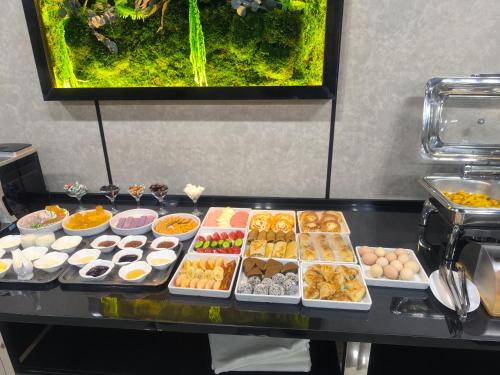 ナボイにあるMaximum Hotelのテーブルの上に並べられたさまざまな種類の食べ物のビュッフェ