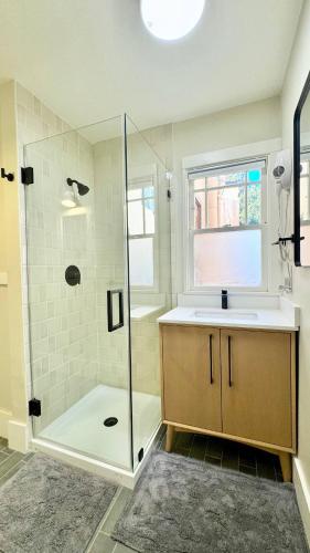 a bathroom with a shower and a sink and a glass shower backdoor at Downtown Historic Spanish Bungalow, with Parking in San Jose