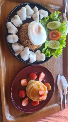 贝都古eM eR GLAMPING & VILLAS的木桌上两盘食物