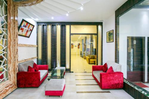 un soggiorno con due sedie rosse e un tavolo di Hotel O by OYO MM Yellowuds ad Amritsar
