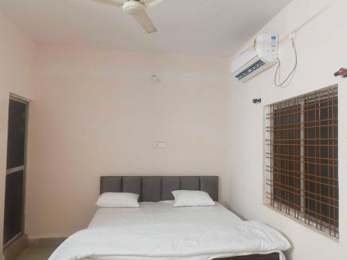 a bed with white sheets in a room at Hotel O Green Villa in Bilāspur