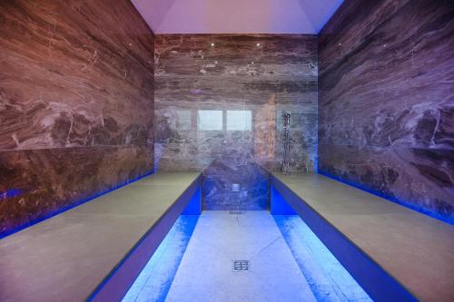 a large room with a stone wall with a long bench at Art Hotel Navigli in Milan