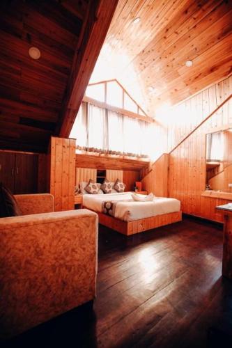 a large room with two beds and a window at Retreat Hotel Queen in Darjeeling