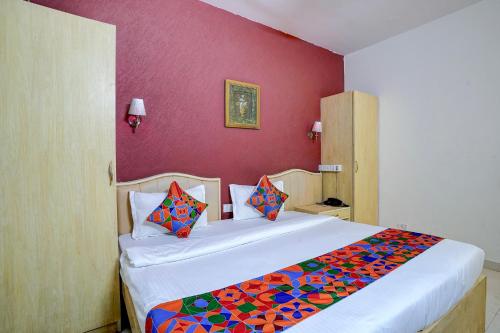 a bedroom with a large bed with colorful pillows at FabHotel Tap Inn in Bengaluru