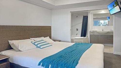 una camera da letto con un letto con una coperta blu e bianca di Ocean Jewel a Ettalong Beach