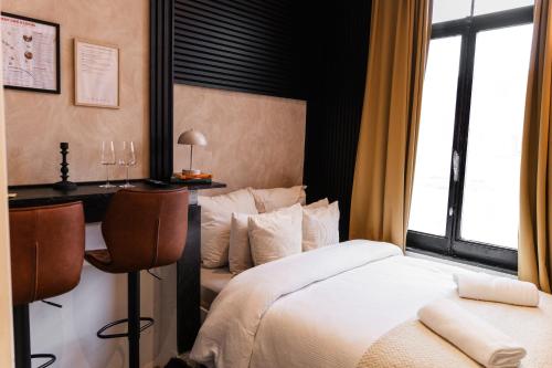 ヘントにある3 Stylish Studios at a Great Location in Gentのベッドと机と窓のあるホテルの部屋