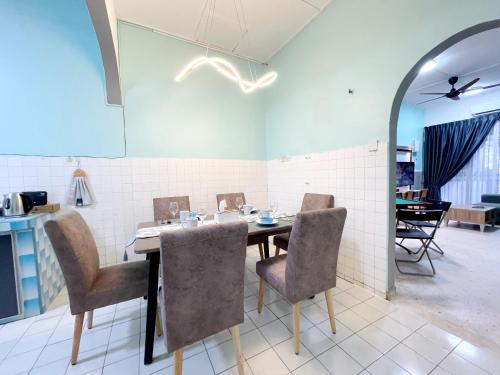 #SP Cozy&Warm 3Bedroom HomeStay 10PAX by S&T Homez في سِريمبان: غرفة طعام مع طاولة وكراسي