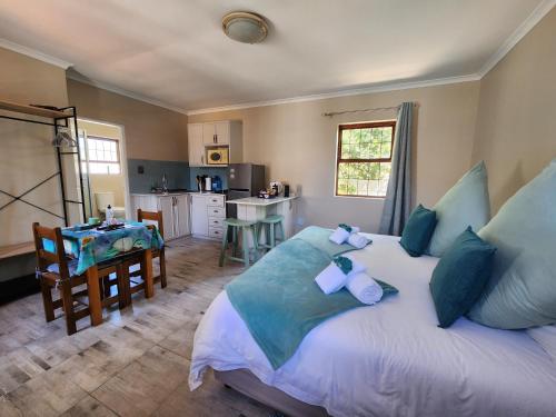 a bedroom with a large bed and a kitchen at Alcyone in Gqeberha