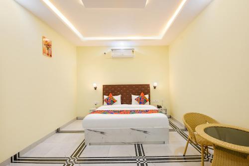 a bedroom with a bed and chairs in it at FabHotel Rubicon in Faridabad