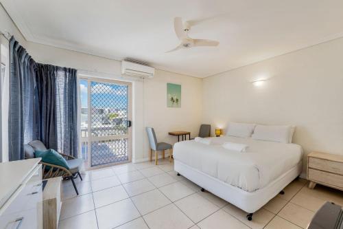 een witte slaapkamer met een bed en een raam bij Shoreline Apartments - Unit 4b in Bargara