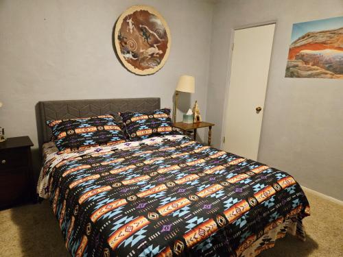 a bedroom with a bed with a colorful comforter at Harmony House Homestay in Sedona