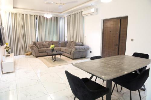 een woonkamer met een tafel en een bank bij Villa Alpaca in Accra