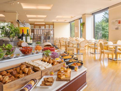 札幌市にあるプレミアホテル -TSUBAKI- 札幌のテーブルと椅子付きの客室でのビュッフェ式料理