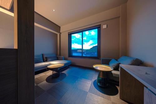 een woonkamer met een bank en een raam bij 中尾甚六hotel in Karatsu