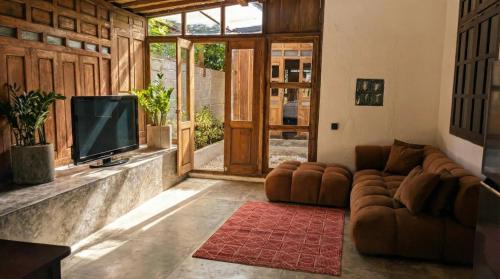ein Wohnzimmer mit Sofa und Fernseher in der Unterkunft NEW The Loft - Uluwatu Surf Ranch in Uluwatu
