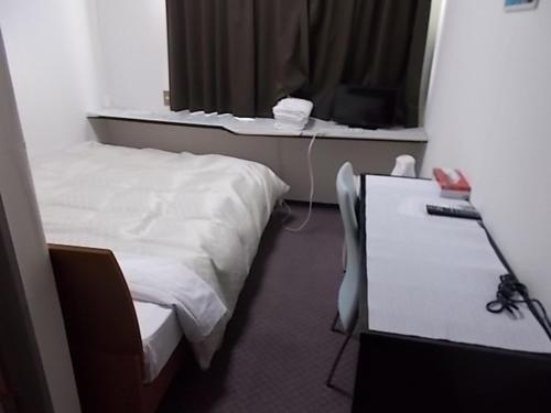a room with a bed and a desk with a mirror at Hotel Avanti in Tokushima