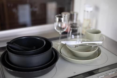 Una encimera con platos, cuencos y copas de vino. en Dennojo, en Nozawa Onsen