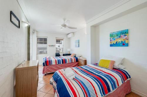 een slaapkamer met 2 bedden in een kamer met een plafond bij Shoreline Apartments - Unit 9b in Bargara