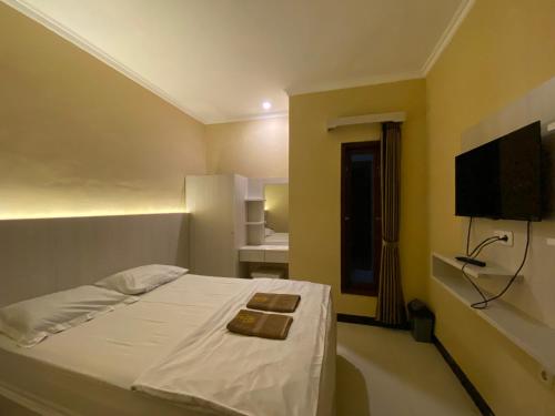 Una televisión o centro de entretenimiento en Omah Joglo Bugis Guest House Syariah Cafe & Resto