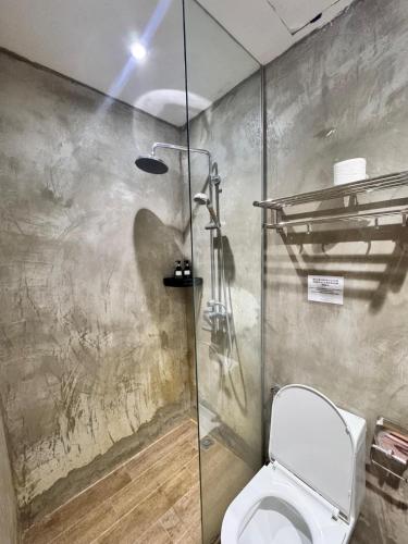 a bathroom with a toilet and a shower at C You Rooms in Semporna