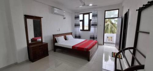 a bedroom with a bed and a mirror at Bayview resort in Weligama