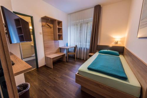 Kleines Zimmer mit einem Bett und einem Tisch in der Unterkunft Hotel Baccara in Aachen