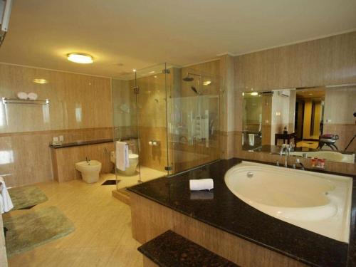 a large bathroom with a tub and a toilet at Grage Hotel Cirebon in Cirebon