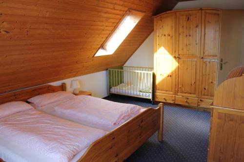 ein Schlafzimmer mit einem Bett mit Holzdecke in der Unterkunft GLÜCKSHAUS Ferienwohnung in Cuxhaven