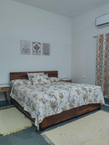 a bedroom with a bed with a floral bedspread at Virudravilla in Jodhpur