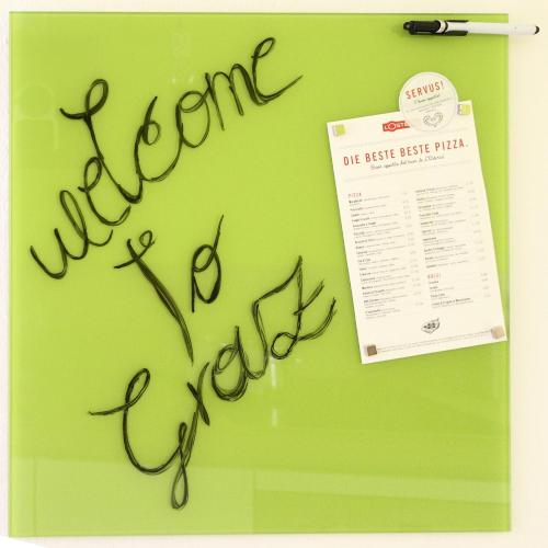 a handwritten signature on a green table with a paper at Apartment-Joanneum in Graz