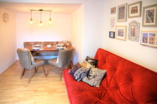 a living room with a red couch and a table at Apartment-Joanneum in Graz