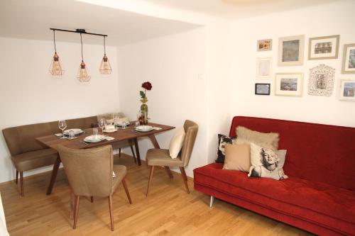 a living room with a table and a red couch at Apartment-Joanneum in Graz