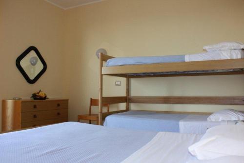 sypialnia z 2 łóżkami piętrowymi i lustrem w obiekcie Hotel Turismo w mieście Metaponto