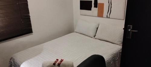 a small bedroom with a bed with two pillows at Diamondfield trading guesthouse in Kimberley