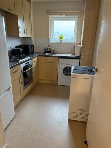 a kitchen with a washer and dryer and a window at Clarkson Court in Hatfield