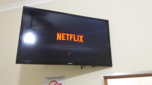 a flat screen tv hanging on a wall at Pousada Flores em Vida in Olímpia