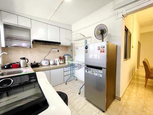 #SE Cozy&Warm 3Bedroom HomeStay 10PAX by S&T Homez في سِريمبان: مطبخ مع ثلاجة ستيل ستانلس وكاونتر