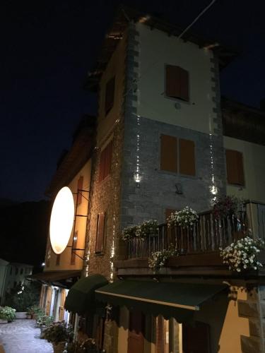 a building with a balcony with plants on it at night at Val Del Rio in Fiumalbo