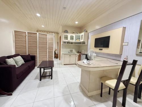 伊洛伊洛Chez Mathilds的配有沙发和桌子的厨房和客厅