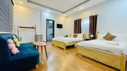 een slaapkamer met 2 bedden en een blauwe bank bij Chic Studio Huế Homestay in Hue