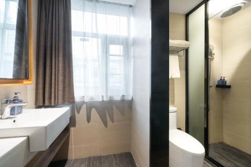 une salle de bain avec un lavabo et des toilettes et une fenêtre dans l'établissement Hanting Premium Hotel Shenzhen Sea World Subway Station, à Shenzhen