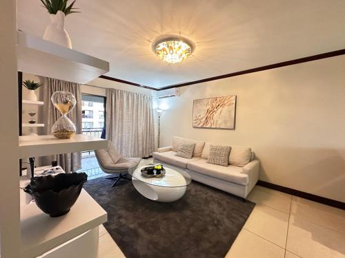 uma sala de estar com um sofá e uma mesa em Cedar Square Apartment em Trevallyn