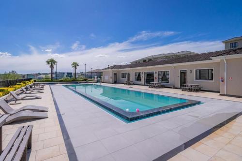 Cedar Square Apartment في Trevallyn: حمام سباحة في الفناء الخلفي للمنزل