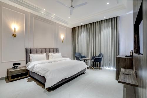 a bedroom with a bed and a table and chairs at Nirvana Hotel & Banquet in Batāla