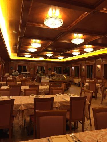 a dining room with tables and chairs and chandeliers at Val Del Rio in Fiumalbo