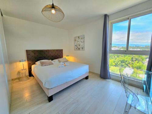 a bedroom with a bed and a large window at Horizon Magellan - Grand T3 de 86m2 - Sainte-Marie in Sainte-Marie