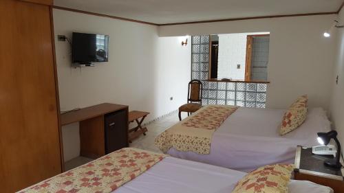 a hotel room with a bed and a television at Windsor Suites Hotel in Santiago