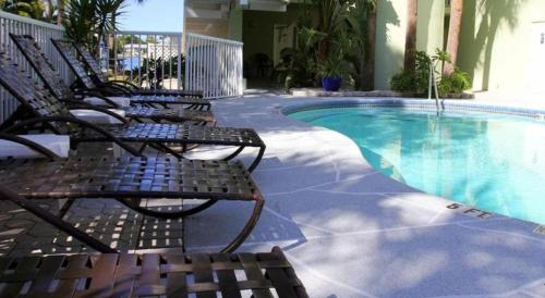 a group of chairs sitting next to a swimming pool at Chart House Suites and Marina in Clearwater Beach